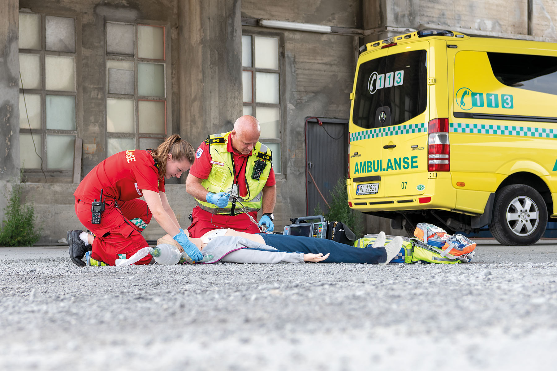 EMS workers outside of ambulance doing simulation training on manikin