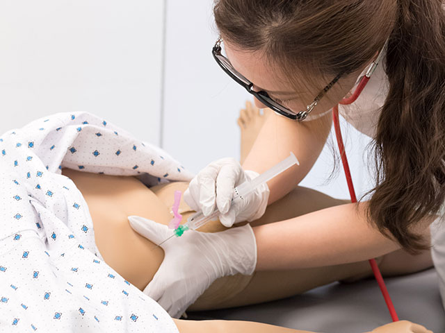 Pielęgniarka wykonująca wklucie podskórne na symulatorze pacjenta Nursing Anne Simulator