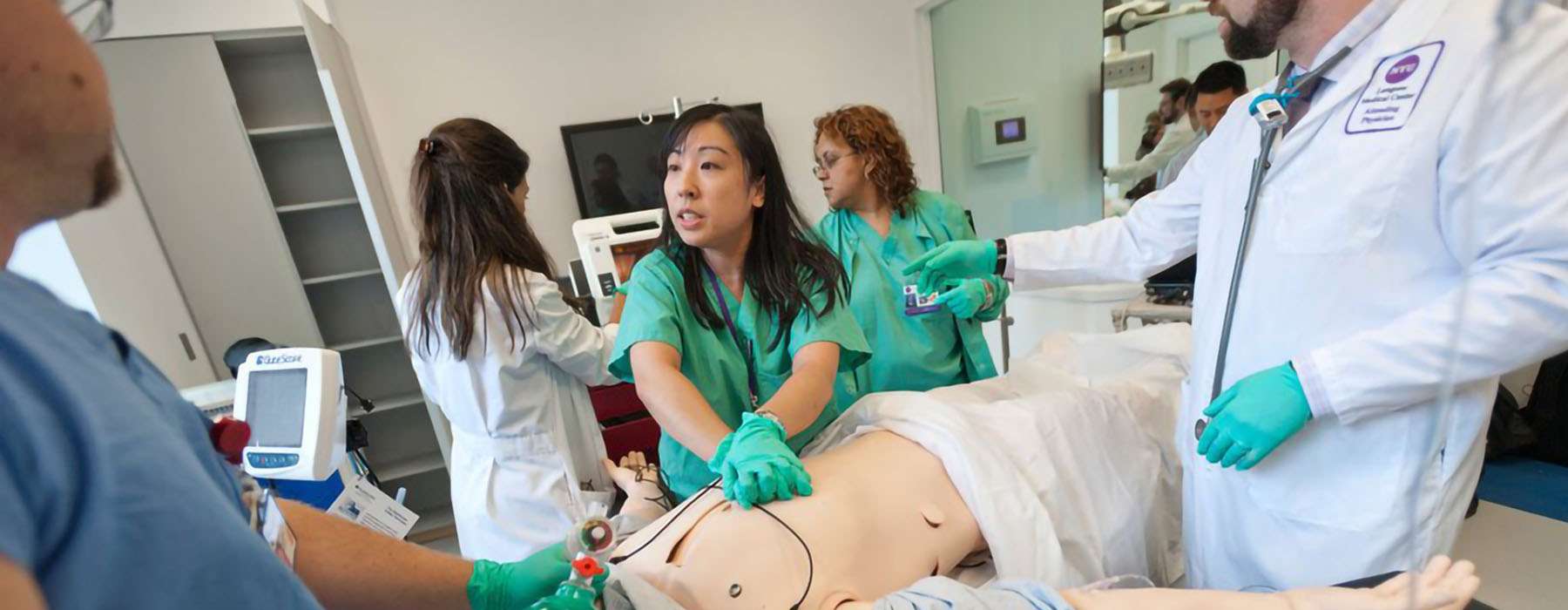 A team of healthcare professionals working doing simulation training on a manikin.