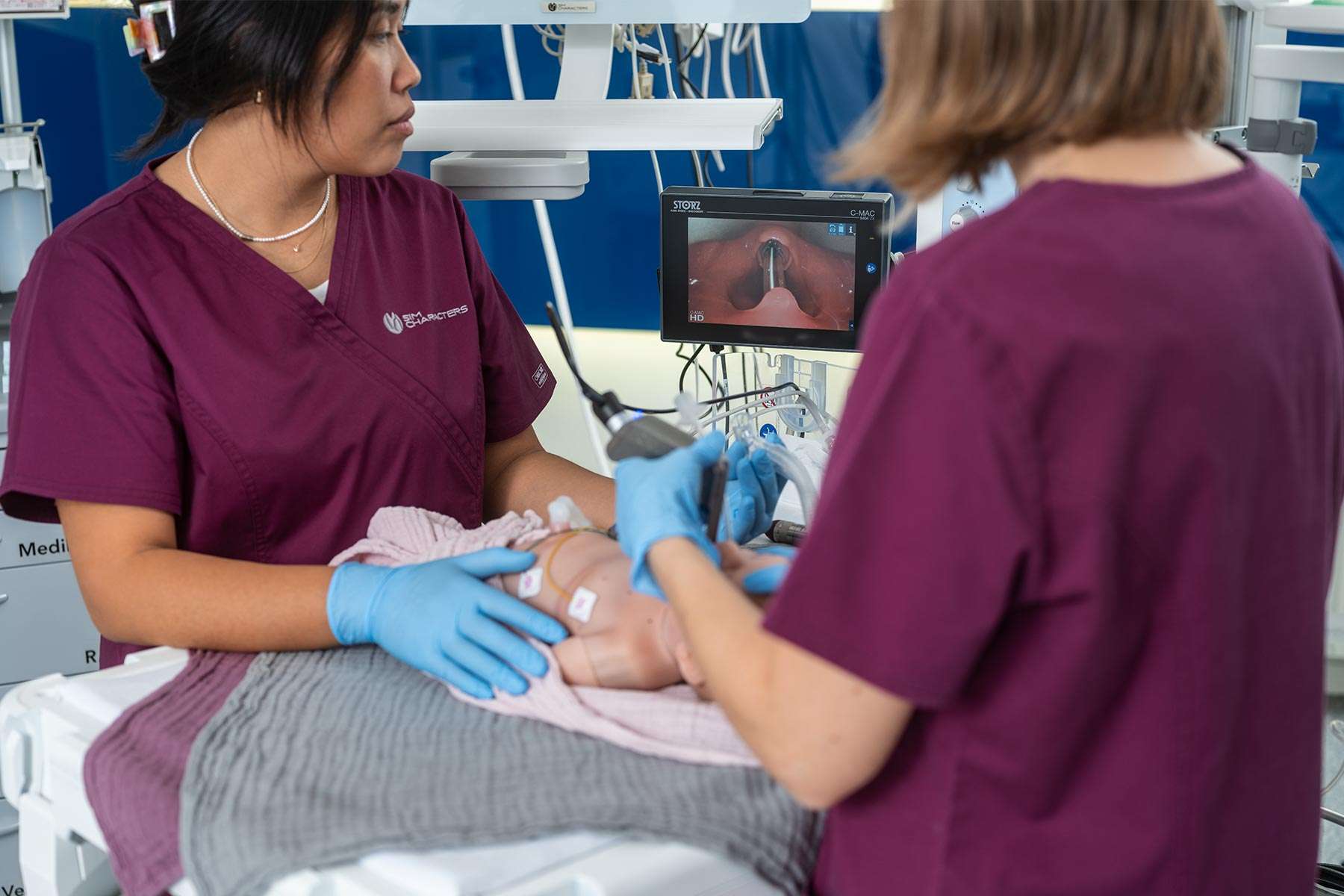 Two nurses checking the airway of Emma
