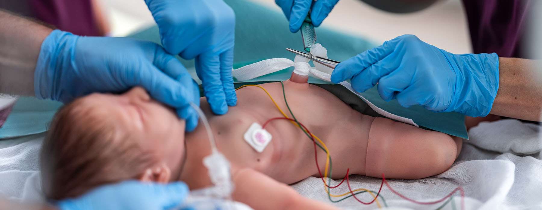 Closeup of simulation training on baby manikin.
