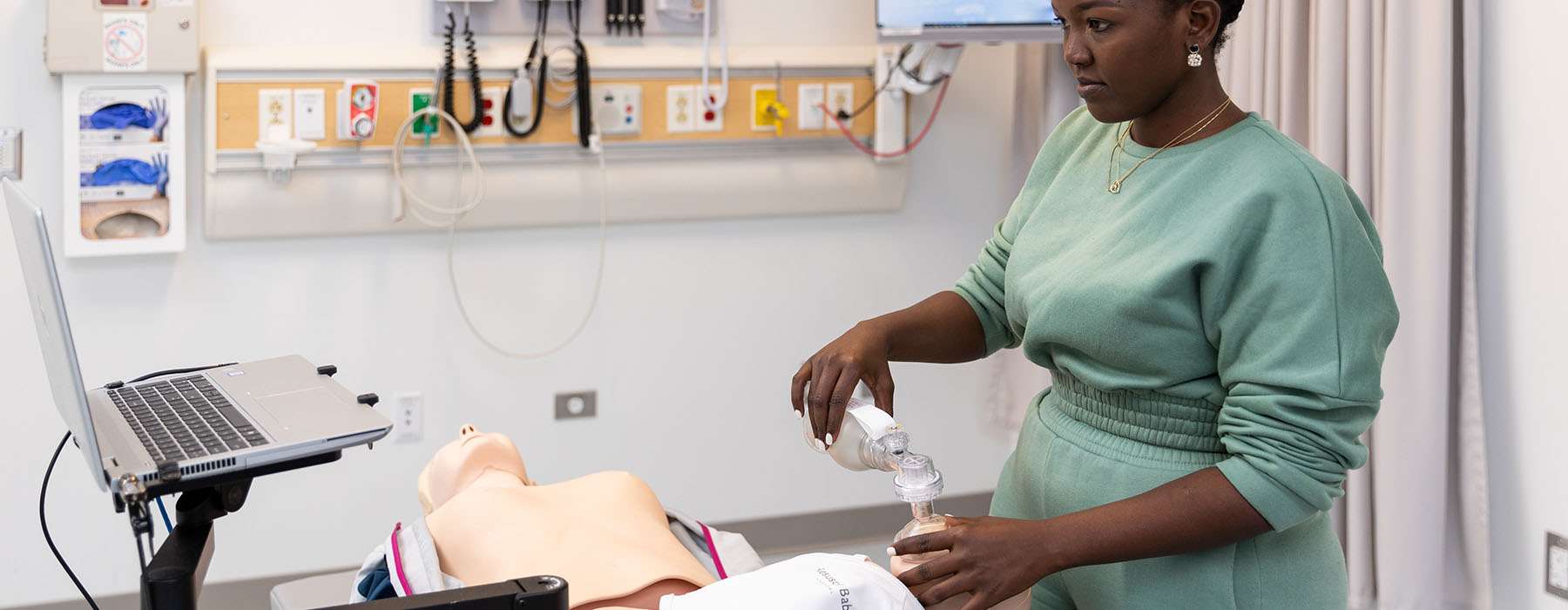 Nursing student training on a BabyAnne manikin.