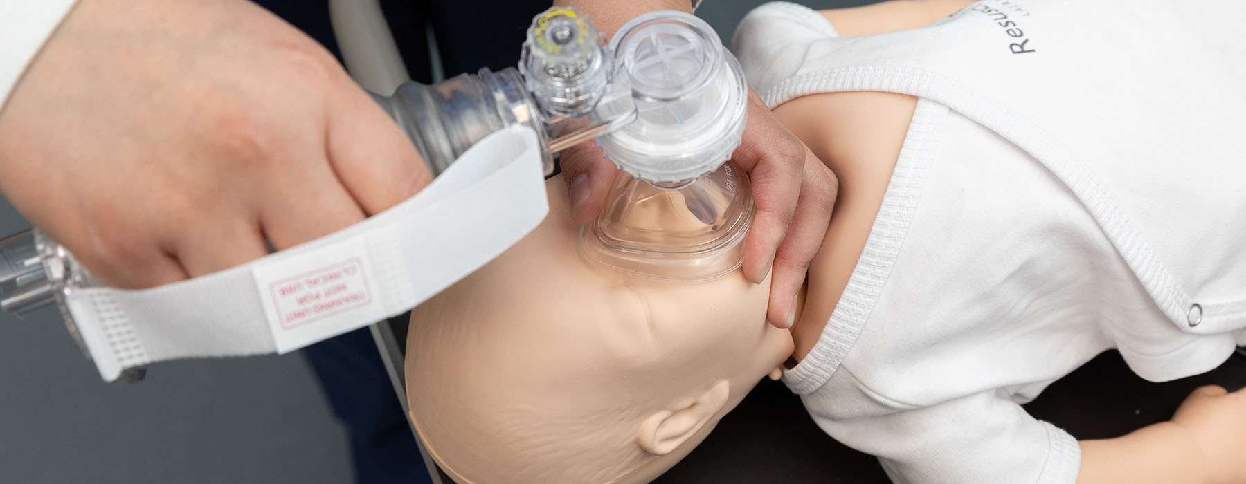 Closeup of CPR training on a baby manikin
