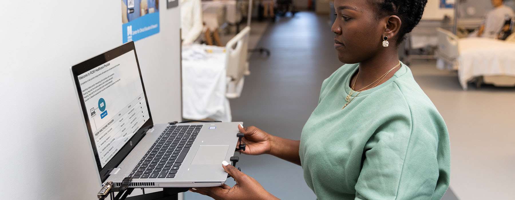 A nurse in training looking at a laptop screen