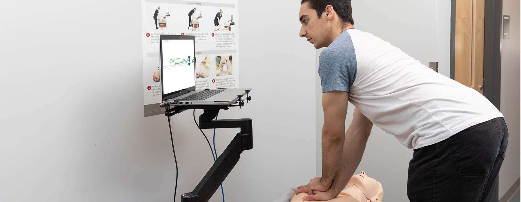 A man practicing CPR on a manikin.