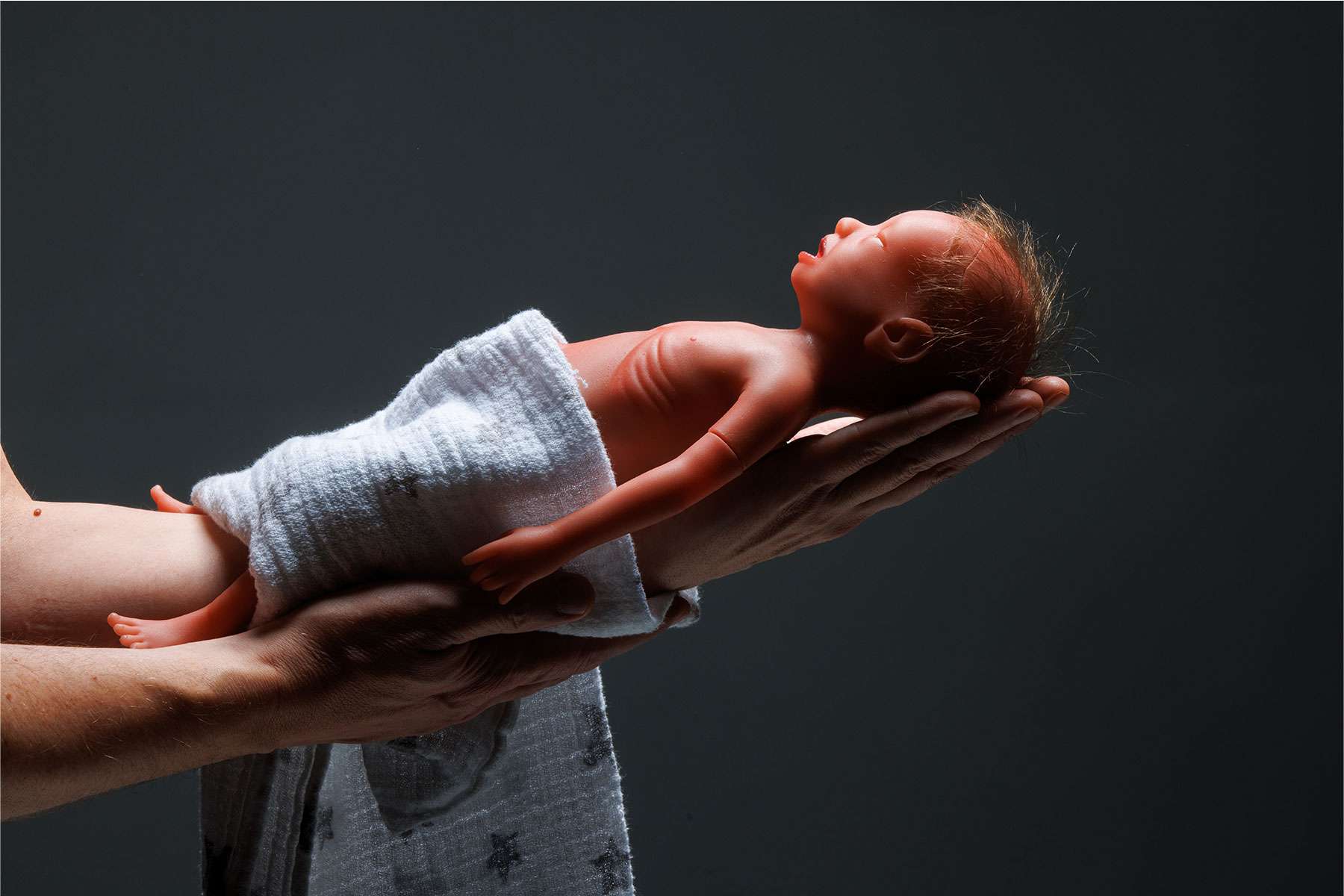 Paul wrapped in blanket being held outward