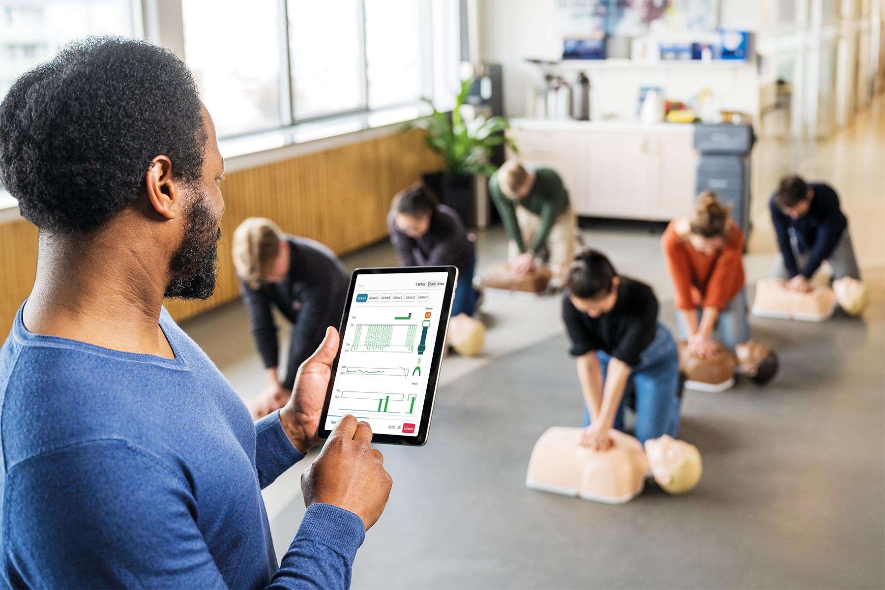 Teacher using QCPR App with a classroom of Little Anne manikins
