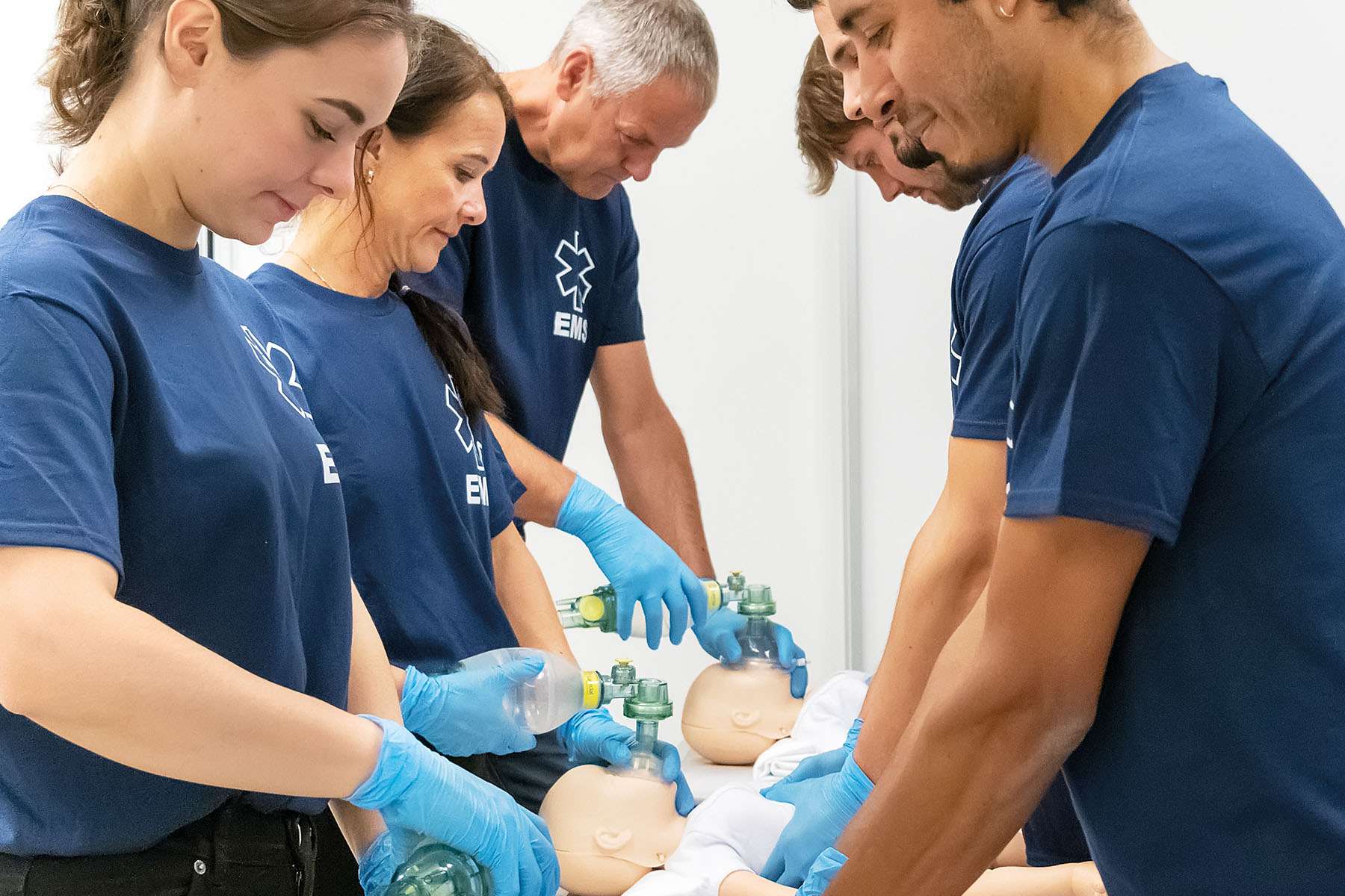 Group of healthcare workers doing simulation training on Resusci Baby QCPR manikins