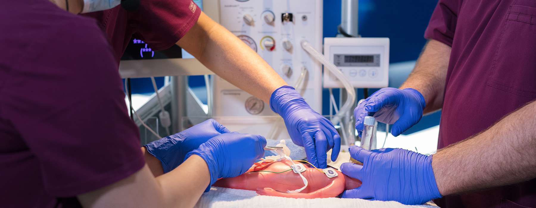 Several healthcare workers working together on NICU simulation training.