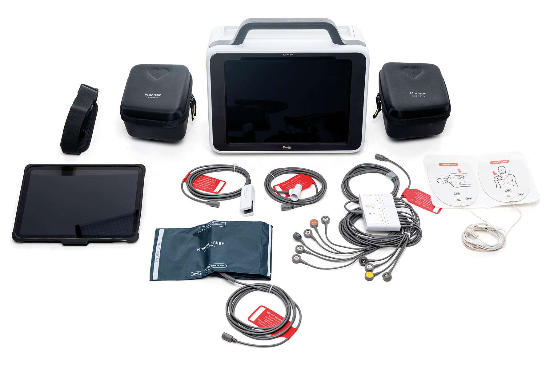 Monitor by Laerdal on white background with accessories to the product placed around it.